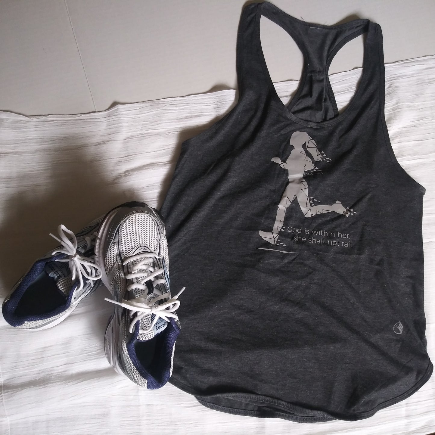 Charcoal grey racerback work-out or running tank top with pink reflective abstract running girl and lettering: God is within her, she shall not fail. Psalm 46:5 on front, centered.